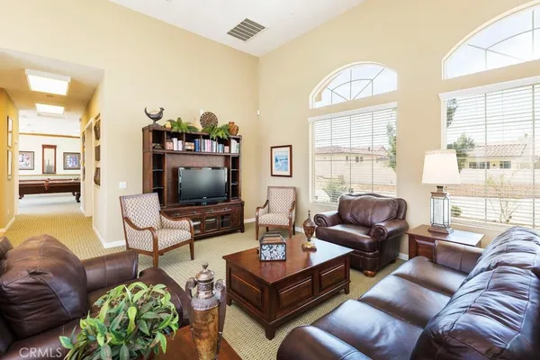 a living room with furniture a flat screen tv and a large window