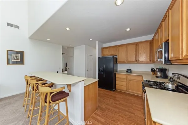 a kitchen with a refrigerator a stove a sink dishwasher with a dining table and chairs