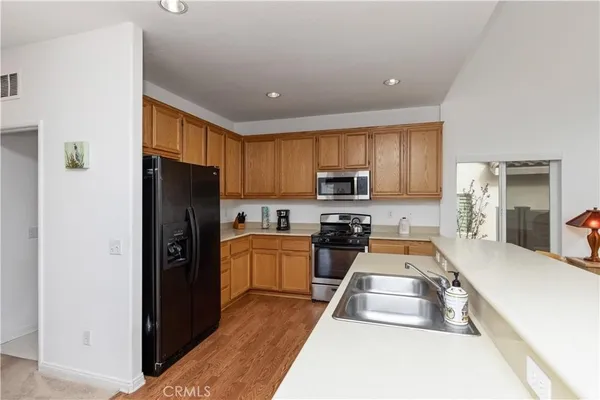a kitchen with stainless steel appliances granite countertop a refrigerator stove microwave and sink