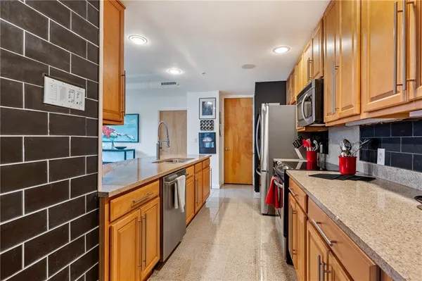 a large kitchen with stainless steel appliances granite countertop a sink and cabinets