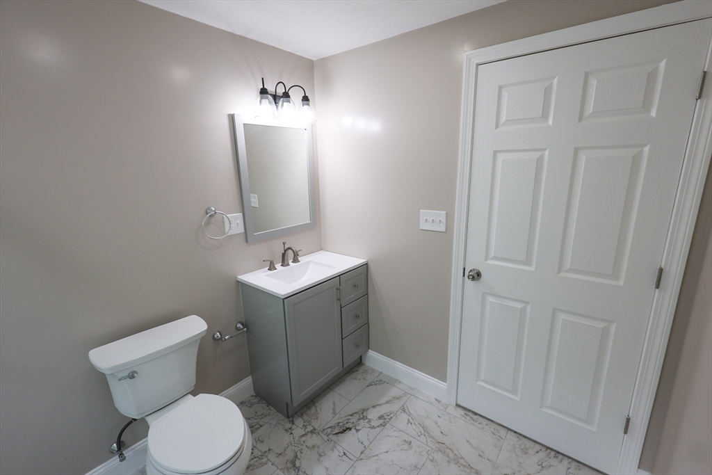 70 Mt Hope Street, Unit 2 Boston, MA 02131 - Photo 15 of 19 a bathroom with a toilet sink and mirror