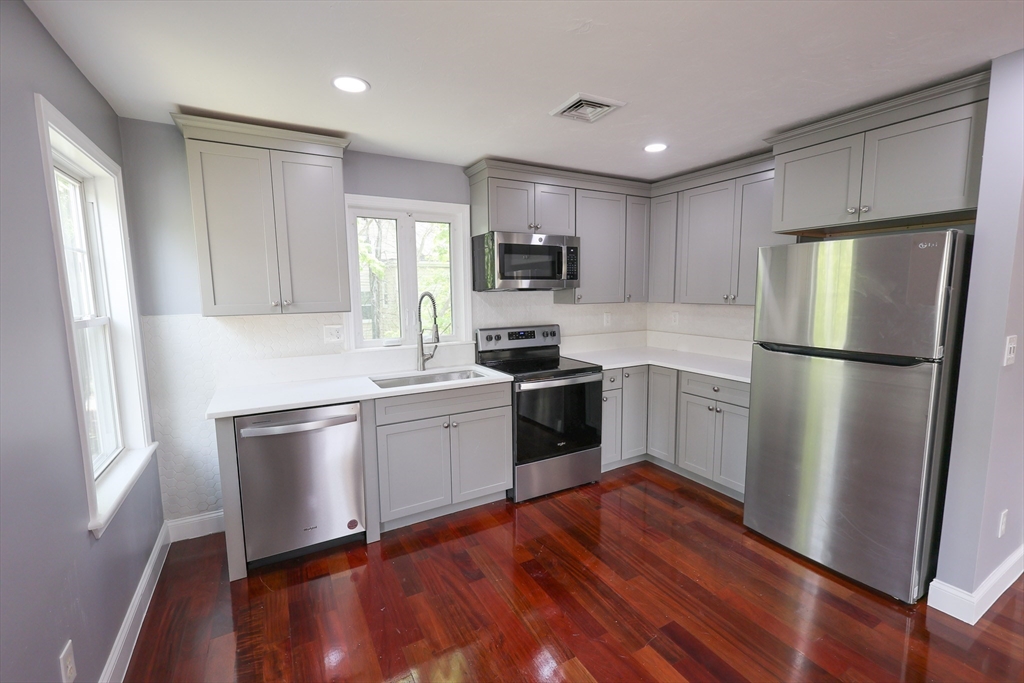 70 Mt Hope Street, Unit 2 Boston, MA 02131 - Photo 2 of 19 a kitchen with a refrigerator cabinets and wooden floor