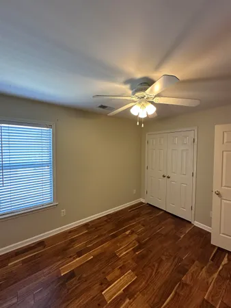 a view of a room with wooden floor and chandelier fan
