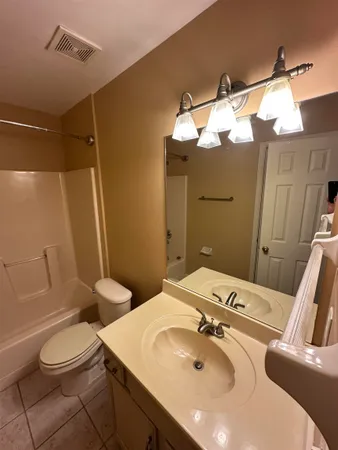 a bathroom with a sink and mirror with toilet