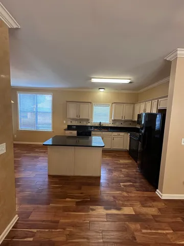 a kitchen with stainless steel appliances kitchen island granite countertop a stove a sink and a microwave