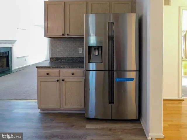 a open kitchen with white cabinets and a fireplace