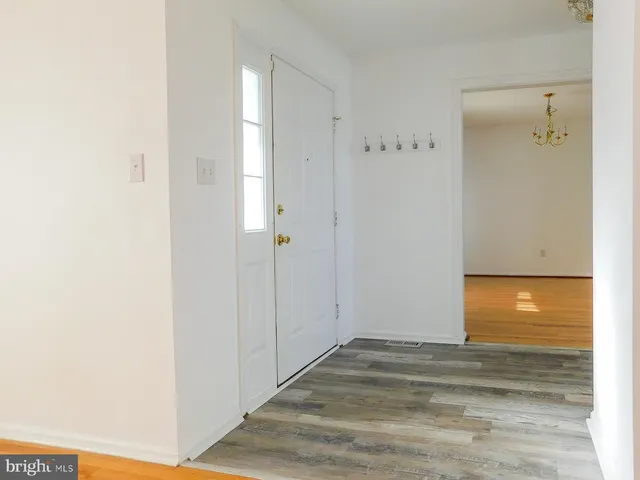 a kitchen with stainless steel appliances white cabinets a sink a stove a microwave and wooden floors