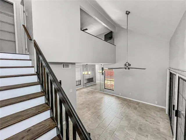 a view of a hallway with stairs and wooden floor