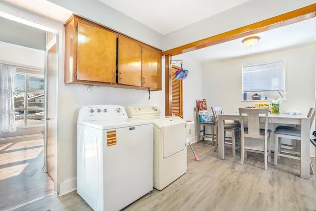 a utility room with dryer washer and a view of living area
