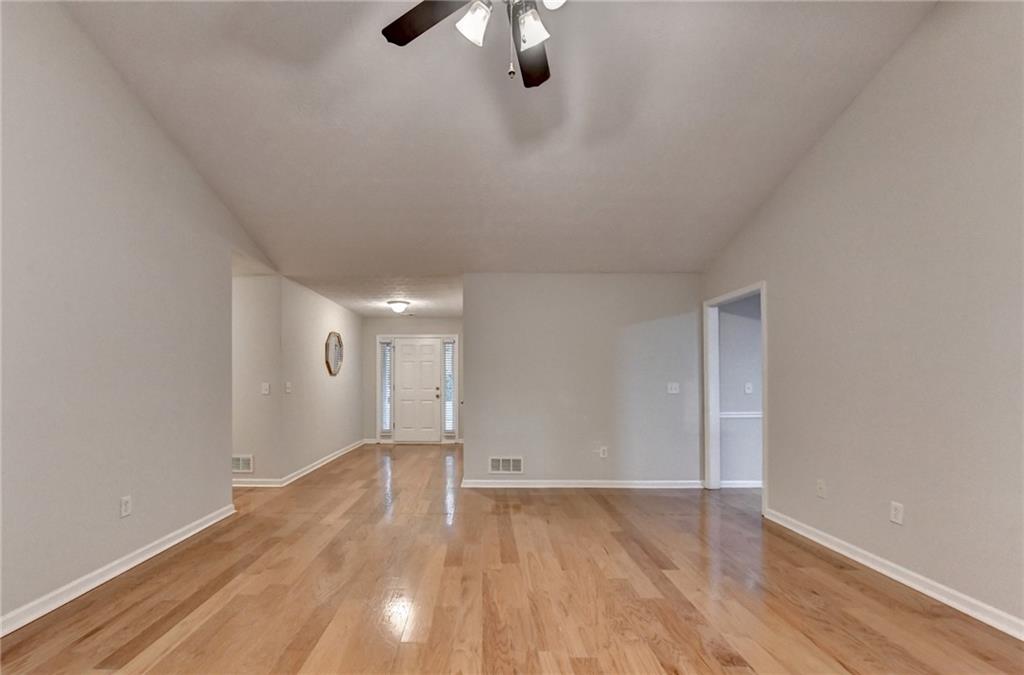 310 Andrew Ridge Drive Jefferson, GA 30549 - Photo 10 of 52 an empty room with wooden floor chandelier fan and windows
