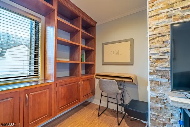a view of a workspace with furniture and a window