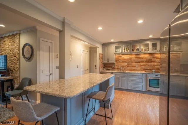 a kitchen with granite countertop kitchen island stainless steel appliances a table and chairs in it