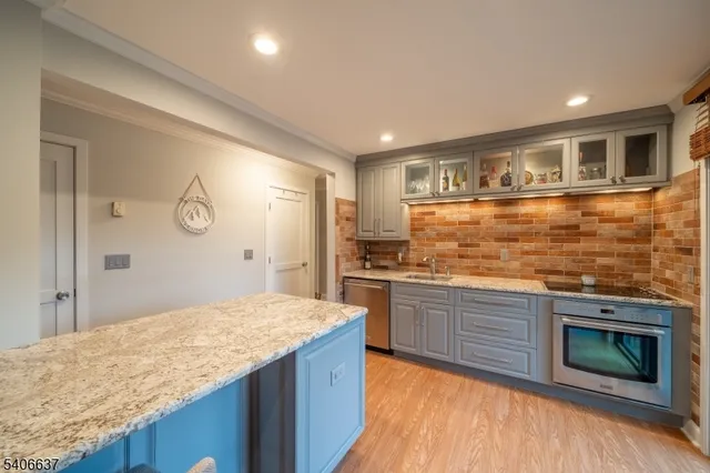 a kitchen with stainless steel appliances granite countertop cabinets and wooden floor