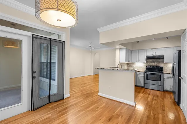 a kitchen with stainless steel appliances granite countertop a sink stove and refrigerator