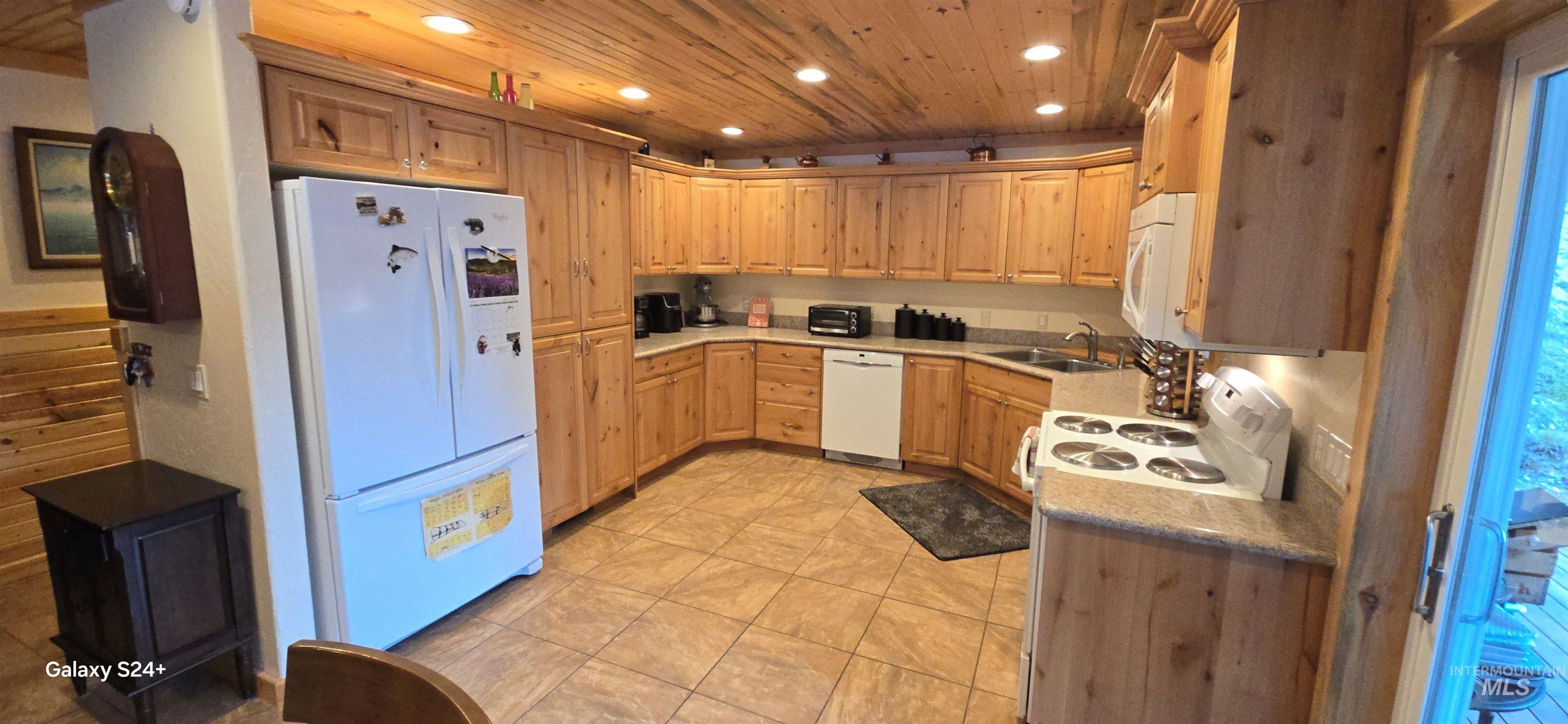 4250 American River Road Elk City, ID 83525 - Photo 15 of 28 Kitchen featuring white appliances, light wood finish cabinetry, light countertops, recessed lighting, and light tile patterned flooring