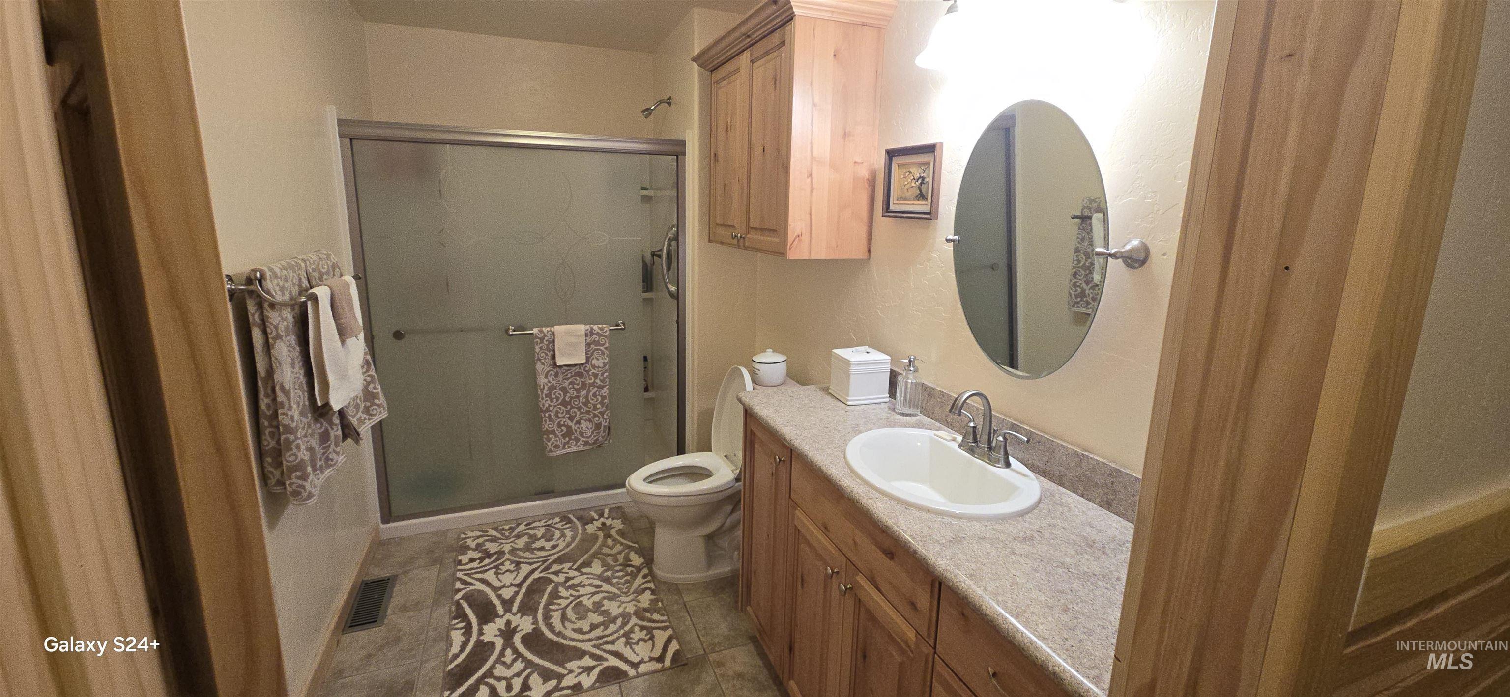 4250 American River Road Elk City, ID 83525 - Photo 23 of 28 Full bath with vanity, a shower stall, and dark tile patterned floors