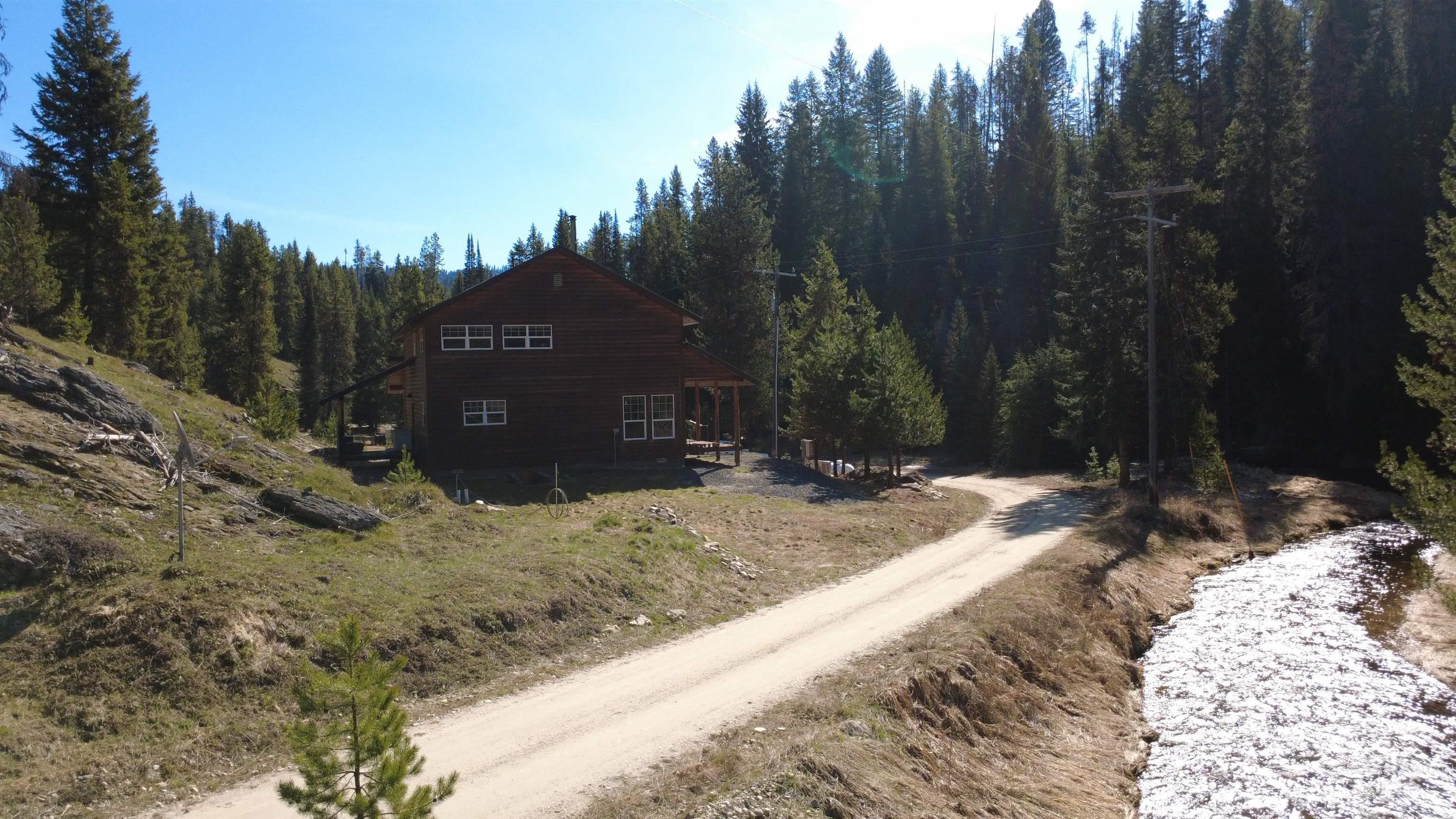 4250 American River Road Elk City, ID 83525 - Photo 46 of 46 View of home's exterior with dirt driveway and a wooded view