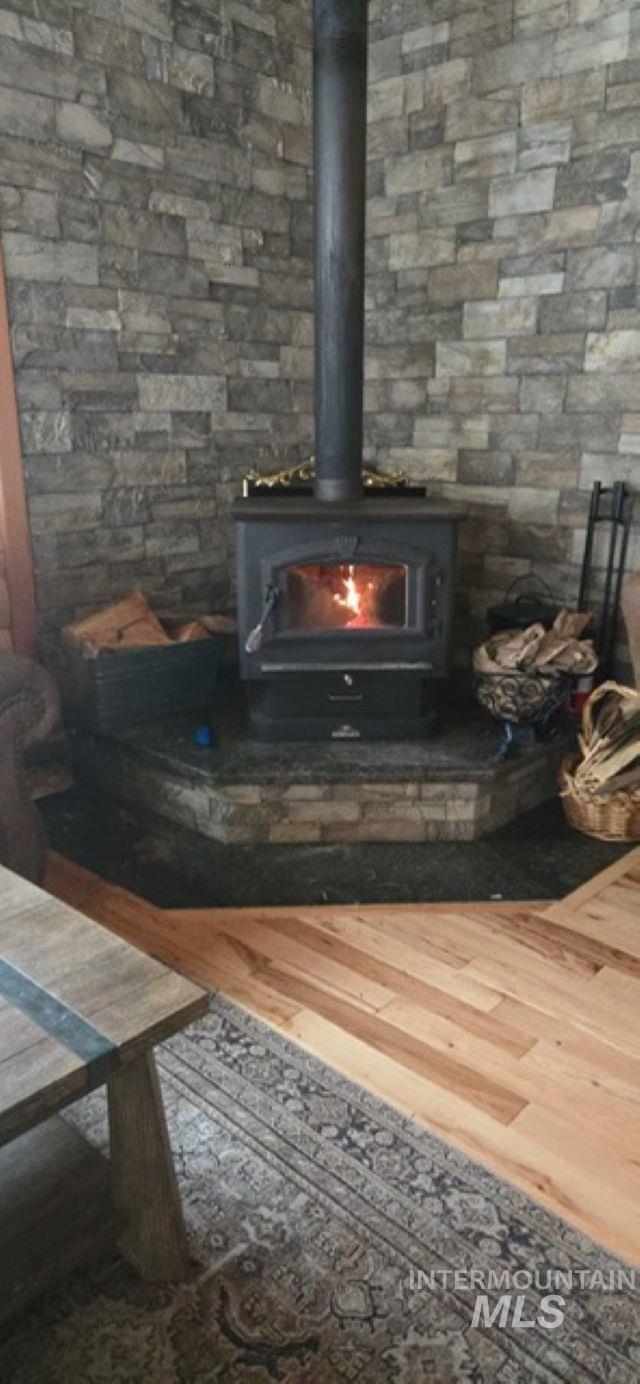 4250 American River Road Elk City, ID 83525 - Photo 9 of 28 Detailed view of a wood stove and wood finished floors