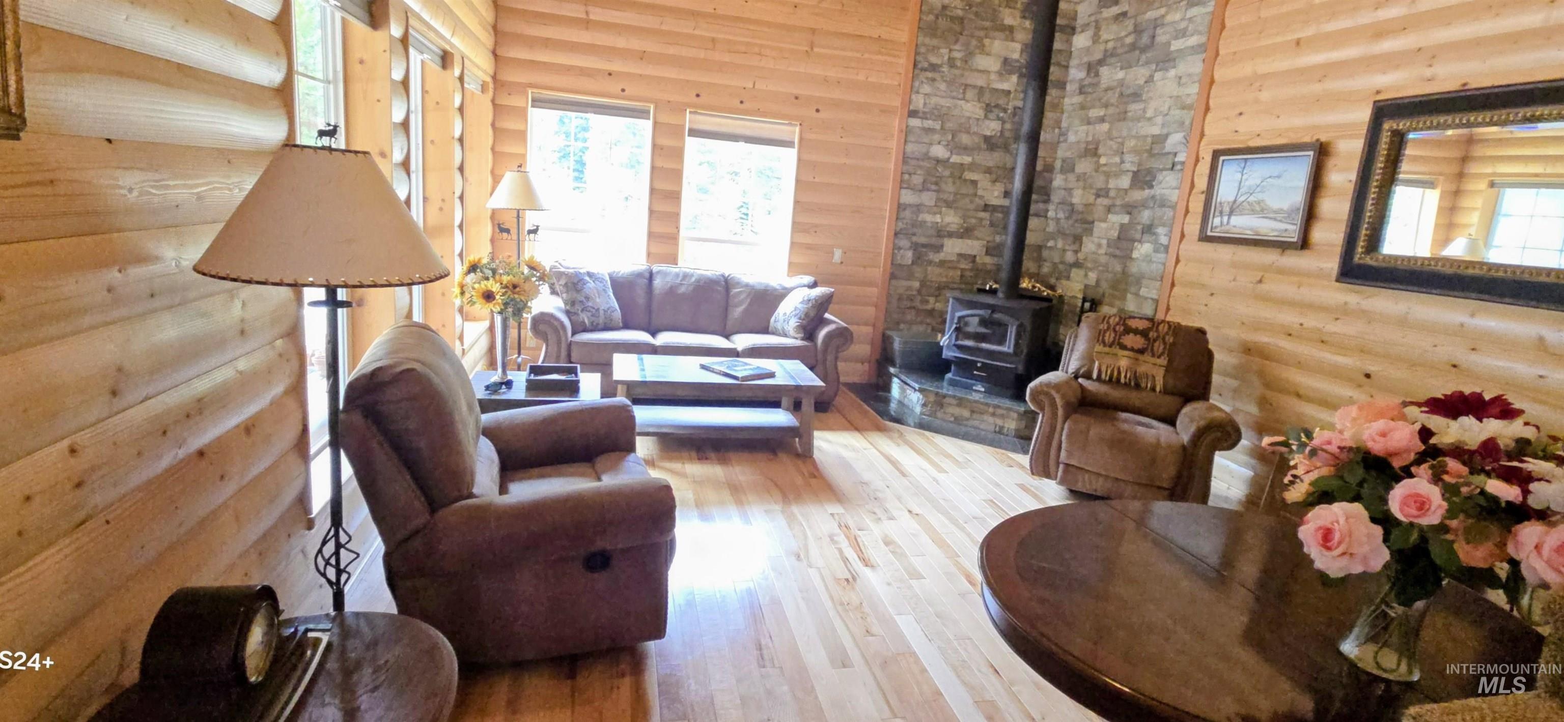 4250 American River Road Elk City, ID 83525 - Photo 10 of 28 Living room featuring a wood stove and light wood-style floors