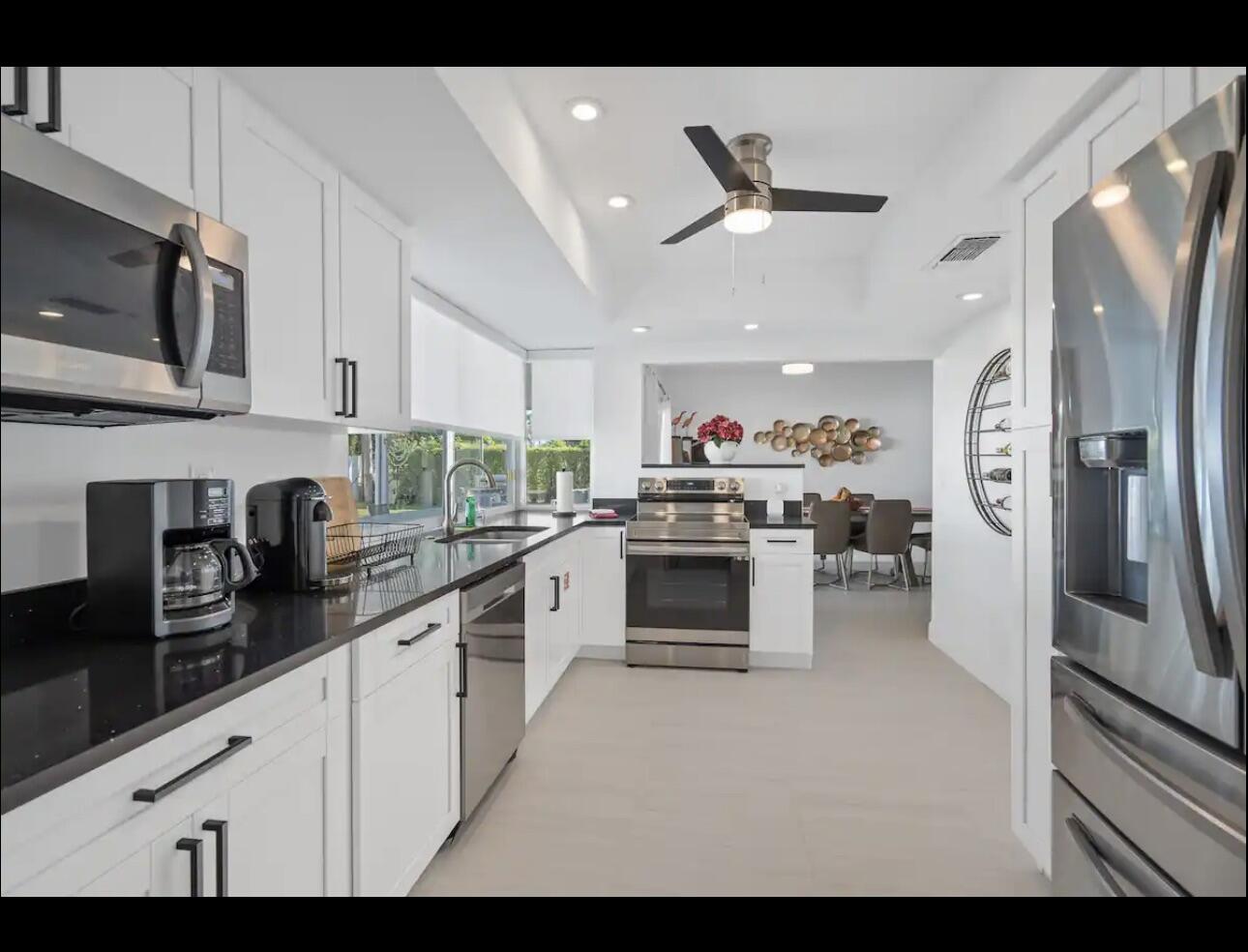 5040 Northeast 22nd Avenue Lighthouse Point, FL 33064 - Photo 13 of 32 a kitchen with stainless steel appliances a refrigerator sink and white cabinets