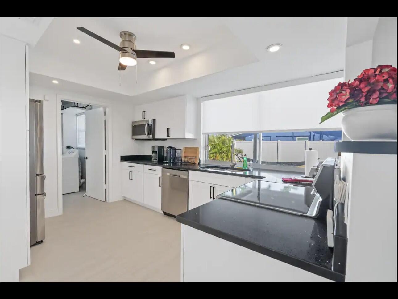 5040 Northeast 22nd Avenue Lighthouse Point, FL 33064 - Photo 16 of 32 a kitchen with a sink stainless steel appliances and white cabinets