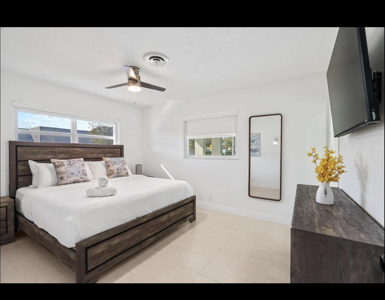5040 Northeast 22nd Avenue Lighthouse Point, FL 33064 - Photo 17 of 32 a bedroom with a bed and a chandelier