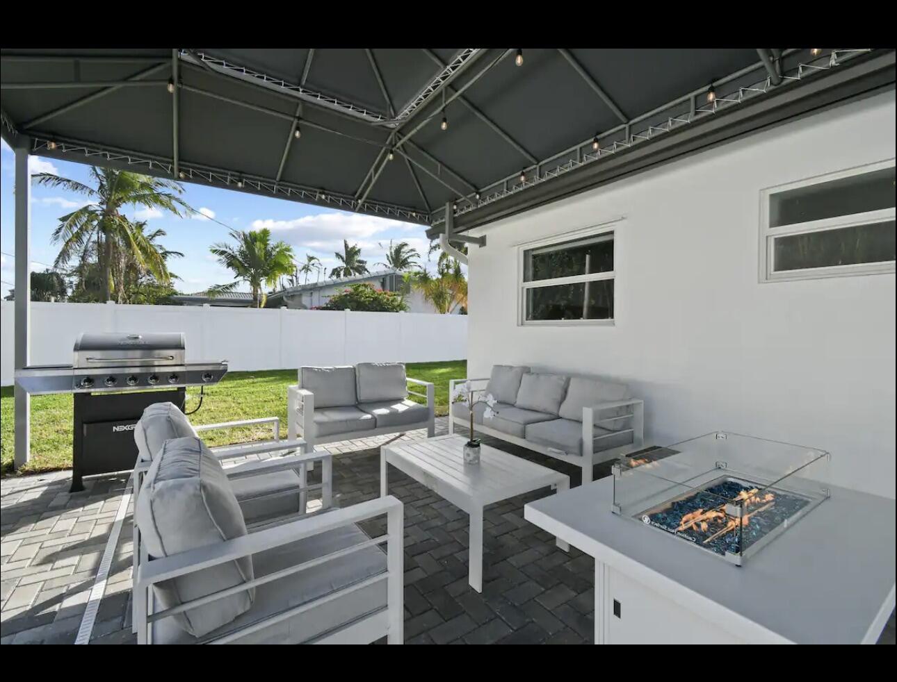 5040 Northeast 22nd Avenue Lighthouse Point, FL 33064 - Photo 22 of 32 a view of a patio with a table and chairs under an umbrella