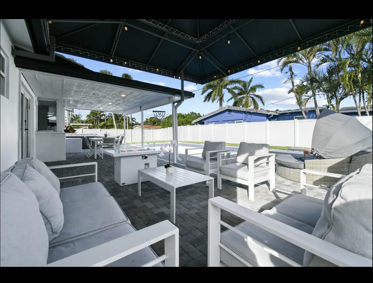 5040 Northeast 22nd Avenue Lighthouse Point, FL 33064 - Photo 24 of 32 a view of a patio with table and chairs under an umbrella