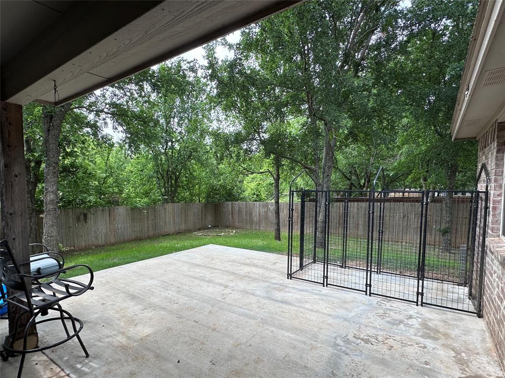 1212 Bowman Ridge Road Stephenville, TX 76401 - Photo 4 of 23 a view of backyard with a large trees and a wooden fence