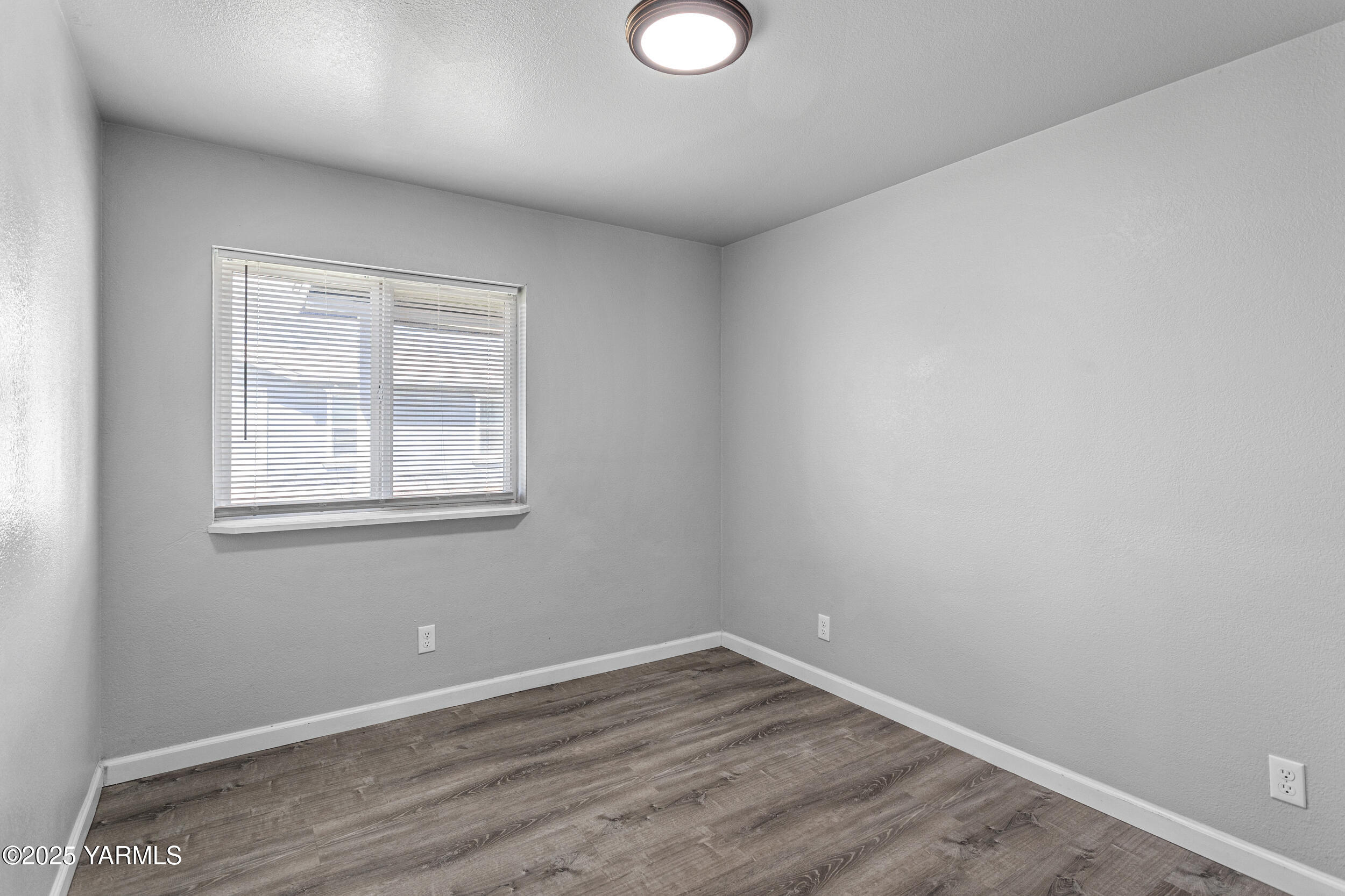 6000 Crestfields Road Yakima, WA 98903 - Photo 11 of 16 an empty room with wooden floor and windows