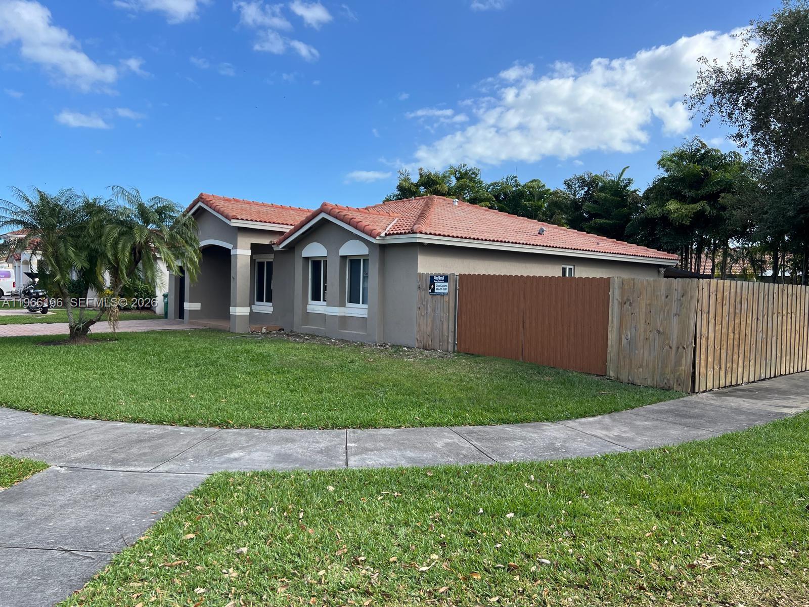 11320 Southwest 245th Street Homestead, FL 33032 - Photo 3 of 21 a front view of a house with a garden