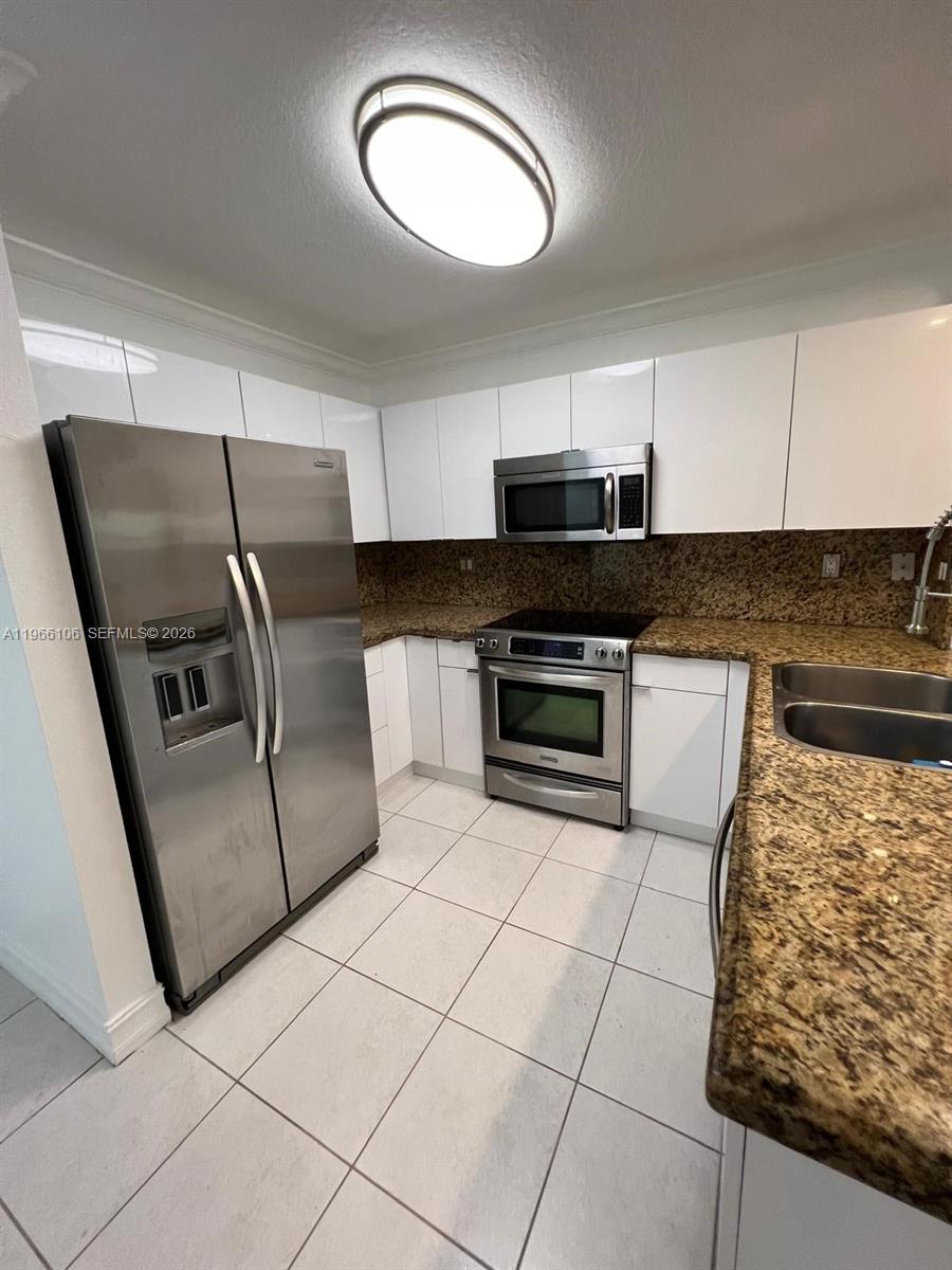 11320 Southwest 245th Street Homestead, FL 33032 - Photo 5 of 21 a kitchen with stainless steel appliances granite countertop a stove a sink and a microwave