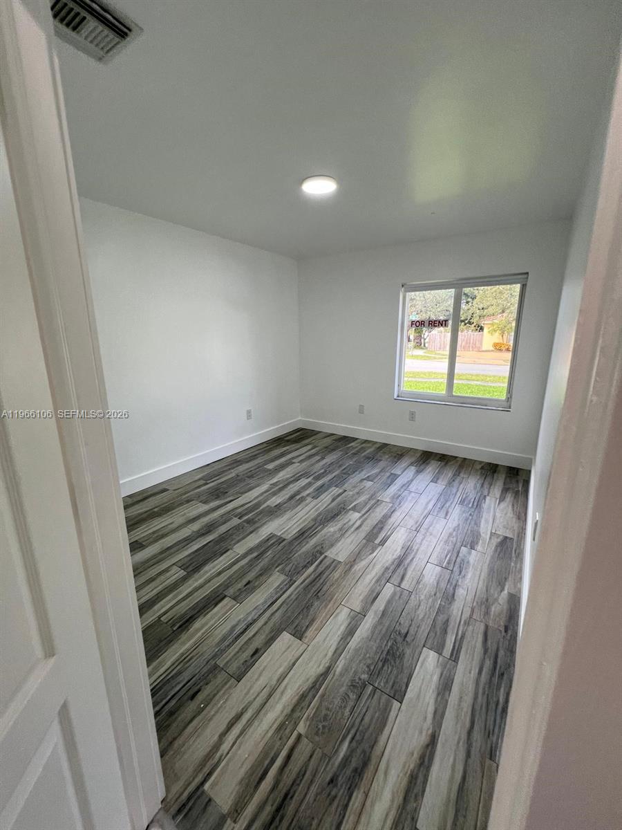 11320 Southwest 245th Street Homestead, FL 33032 - Photo 9 of 21 wooden floor in an empty room with a window