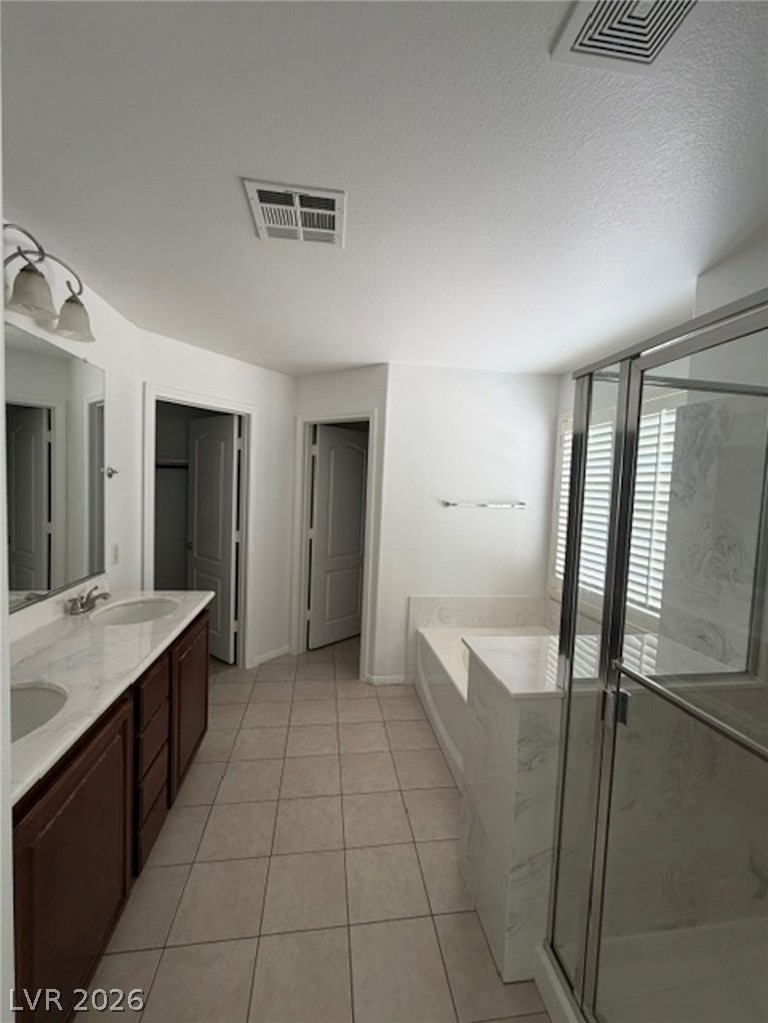 3862 Landing Ridge Place Las Vegas, NV 89135 - Photo 12 of 26 Dual vanity sinks and a separate tub and shower create a functional bathroom space.