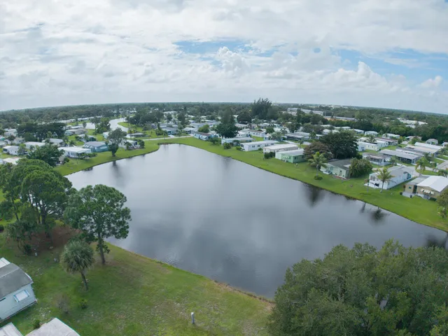 an aerial view of a city with lots of residential buildings lake and mountain view in back