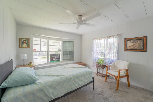 a bedroom with a large bed and a chair