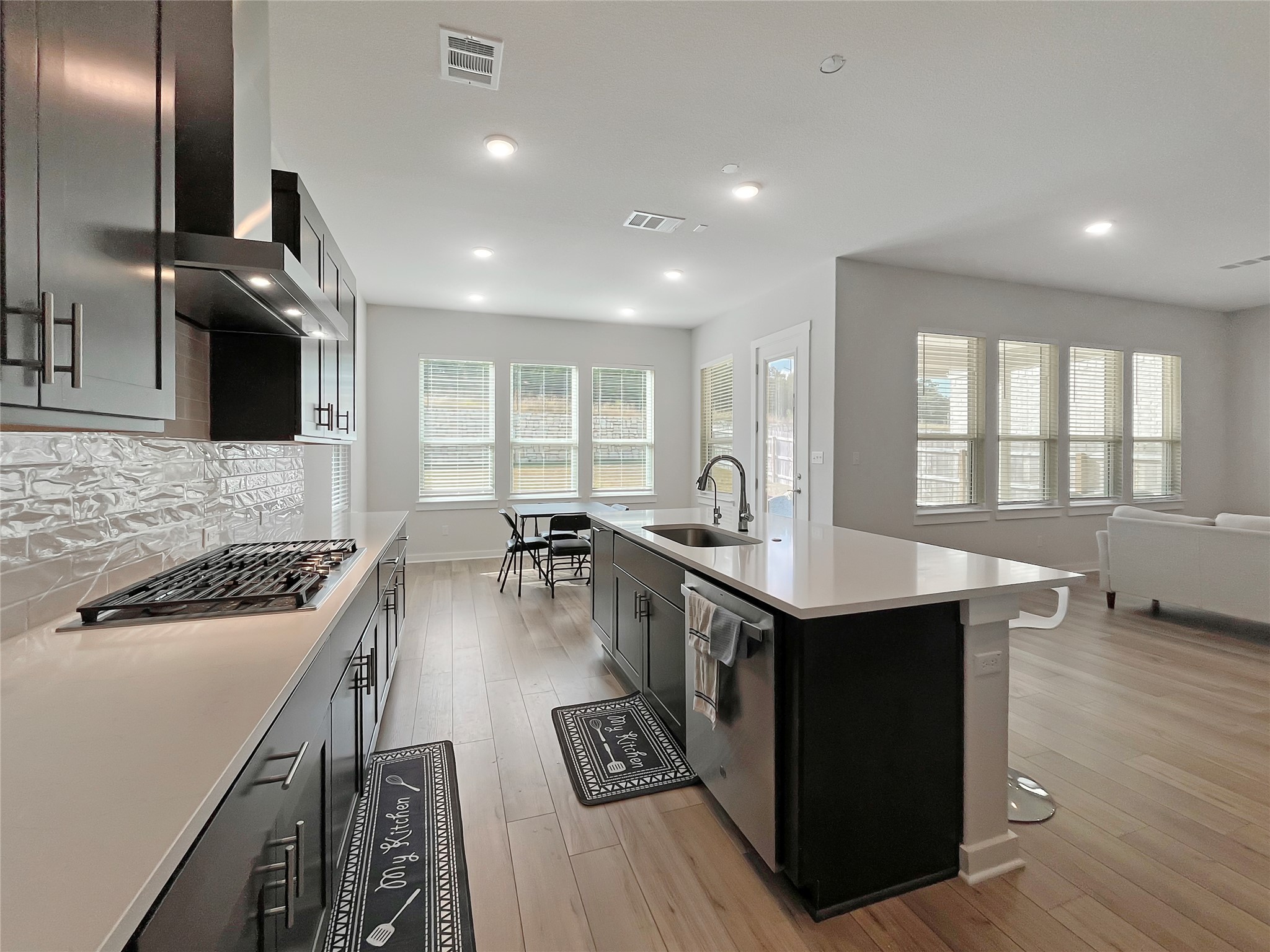 1200 Willie Rnch Way Leander, TX 78641 - Photo 25 of 25 Kitchen featuring open floor plan, appliances with stainless steel finishes, light wood finished floors, a center island with sink, and backsplash