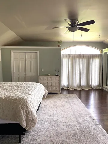 a spacious bedroom with a bed and a window