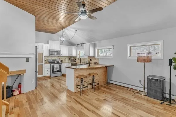 a kitchen with cabinets and wooden floor