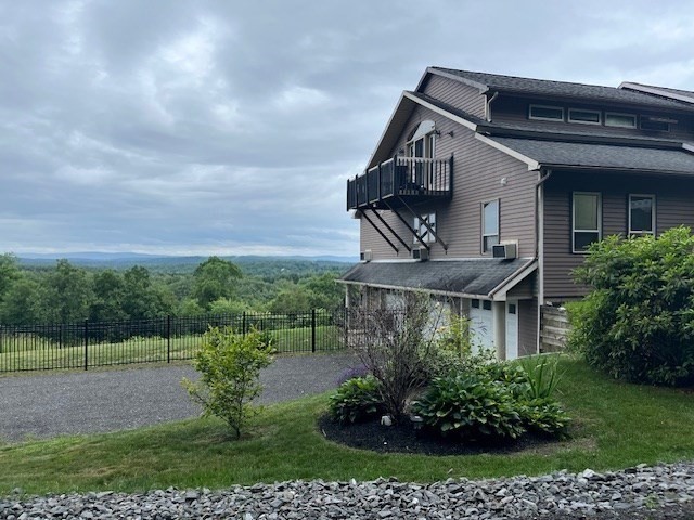 151 Smead Hill Road Greenfield, MA 01301 - Photo 4 of 13 a view of a house with brick walls and a yard with plants