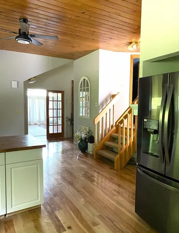 a view of a hallway with wooden floor and staircase