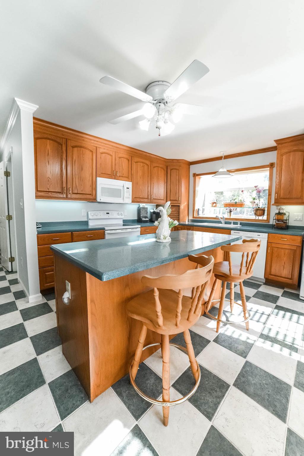 13425 Olivet Road Lusby, MD 20657 - Photo 39 of 59 a dining hall with stainless steel appliances granite countertop a stove a sink a dining table and chairs with wooden floor