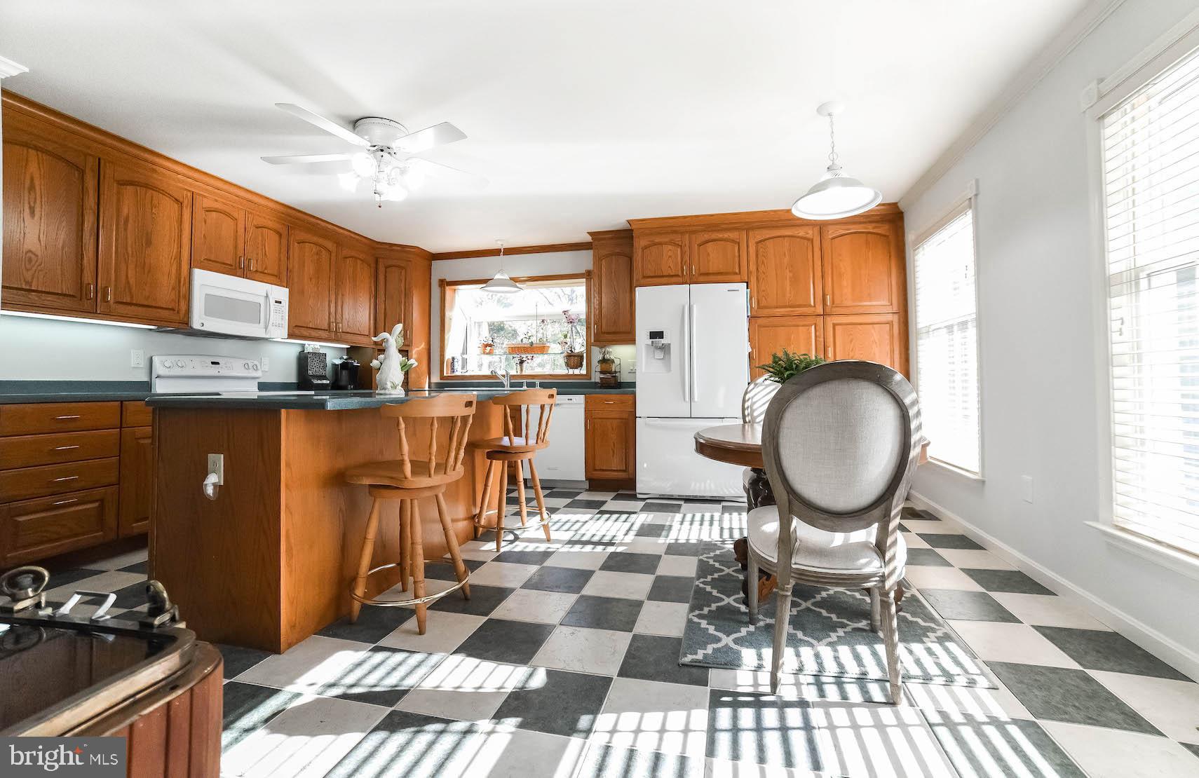 13425 Olivet Road Lusby, MD 20657 - Photo 40 of 59 a open kitchen with stainless steel appliances granite countertop a stove a sink dishwasher a dining table and chairs with wooden floor