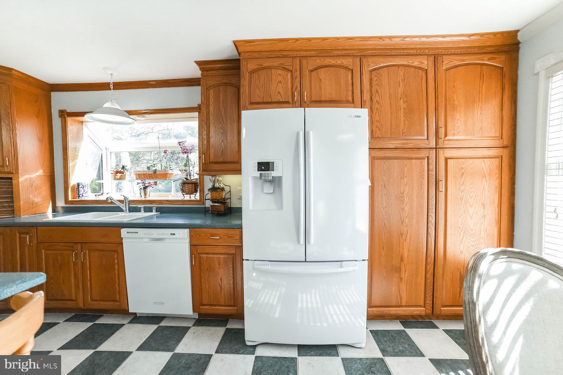 13425 Olivet Road Lusby, MD 20657 - Photo 41 of 59 a kitchen with a refrigerator a sink and white cabinets