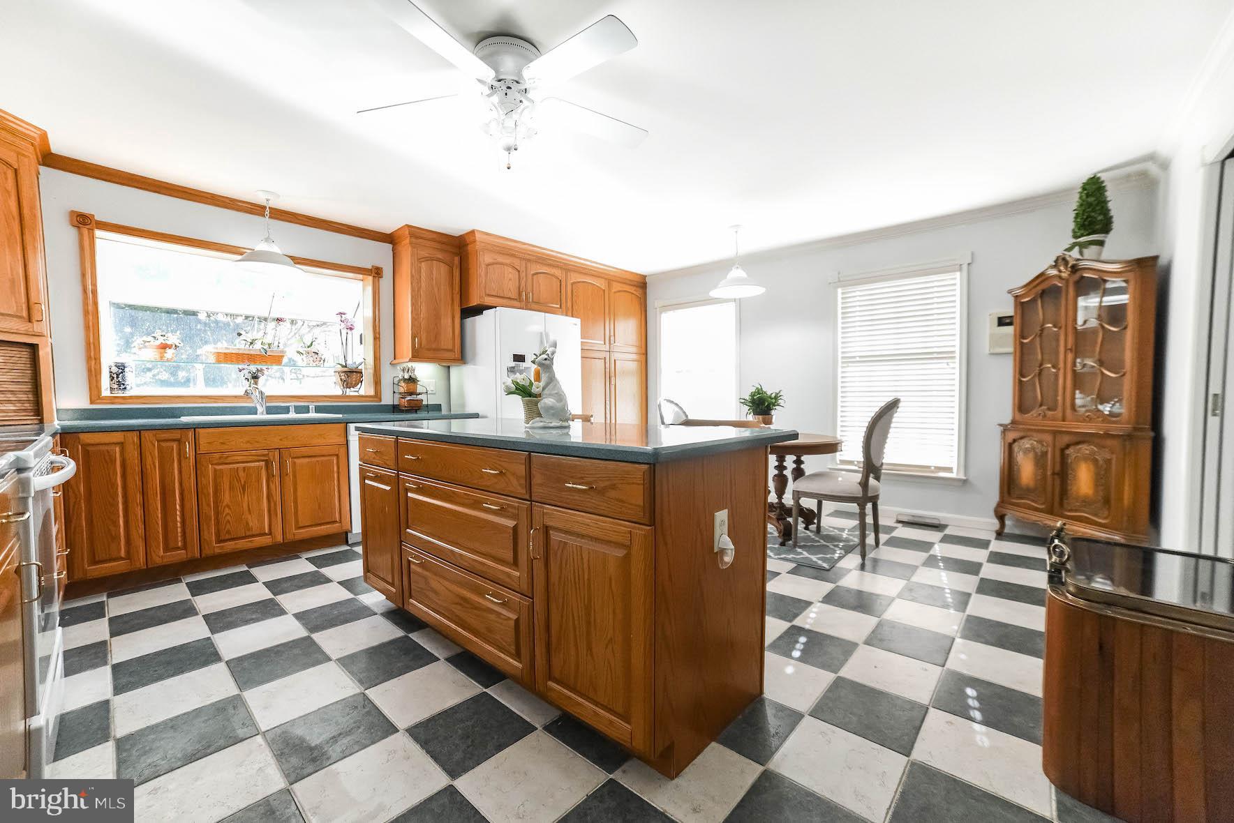 13425 Olivet Road Lusby, MD 20657 - Photo 42 of 59 a kitchen with stainless steel appliances a sink a stove a dining table and chairs with wooden floor