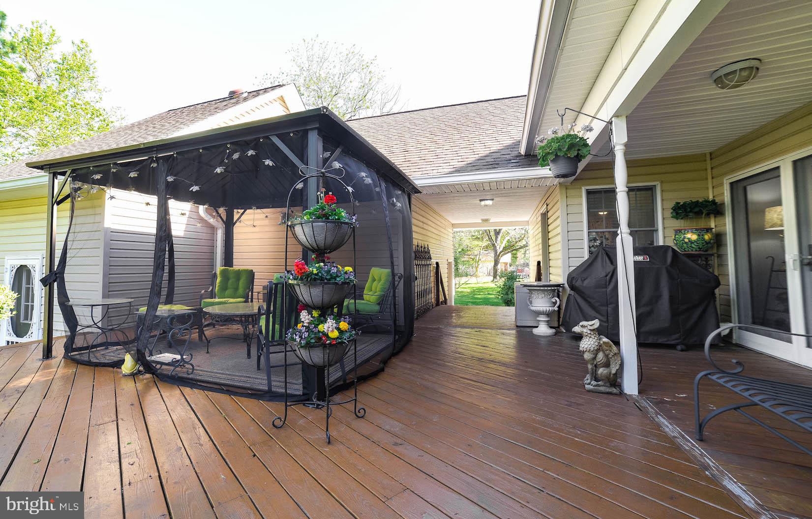 13425 Olivet Road Lusby, MD 20657 - Photo 6 of 59 a view of a patio with table and chairs potted plants with wooden floor