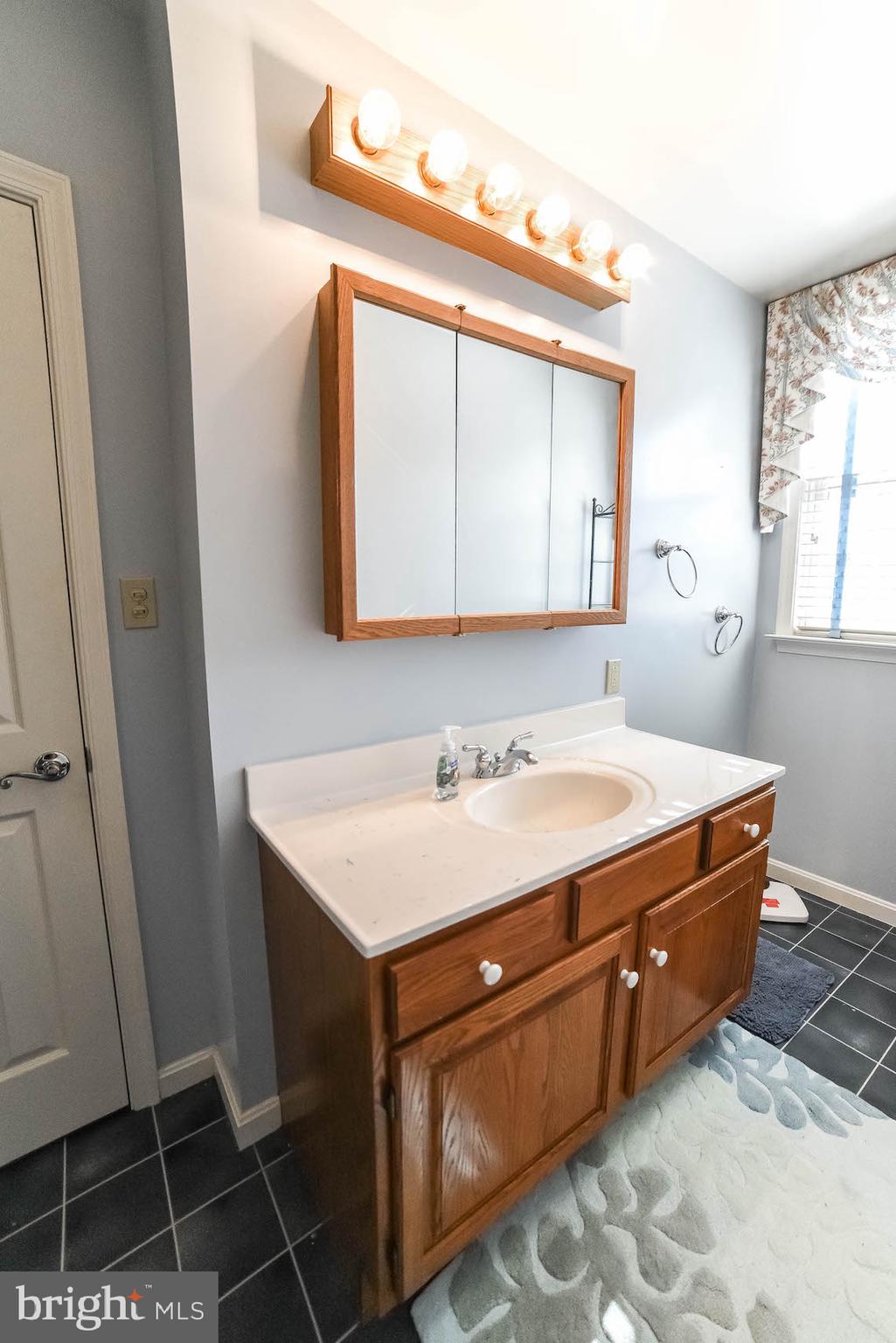 13425 Olivet Road Lusby, MD 20657 - Photo 58 of 59 a bathroom with a sink a mirror and a vanity