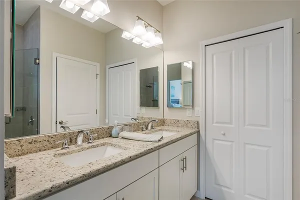 a bathroom with a granite countertop sink and a mirror
