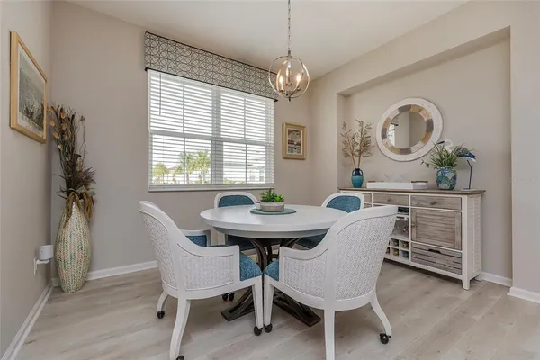 a dining room with furniture a chandelier and window
