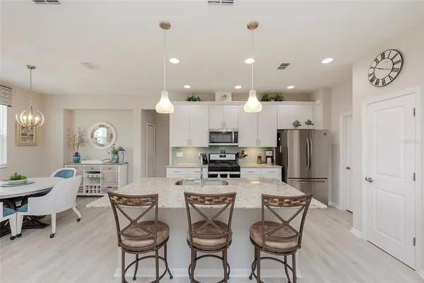 a kitchen with a dining table cabinets and stainless steel appliances